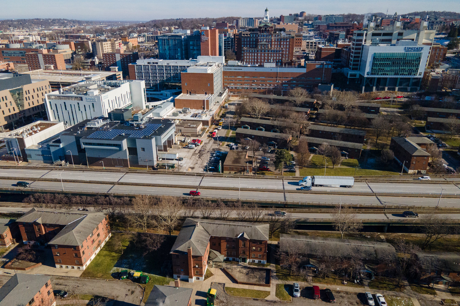 Interstate 81 passes through downtown Syracuse, N.Y., on Monday, Jan. 16, 2023. On the west side of the roadway are the Pioneer Homes public housing projects. Hospitals, hotels and other buildings are visible on the east side. (AP Photo/Ted Shaffrey)