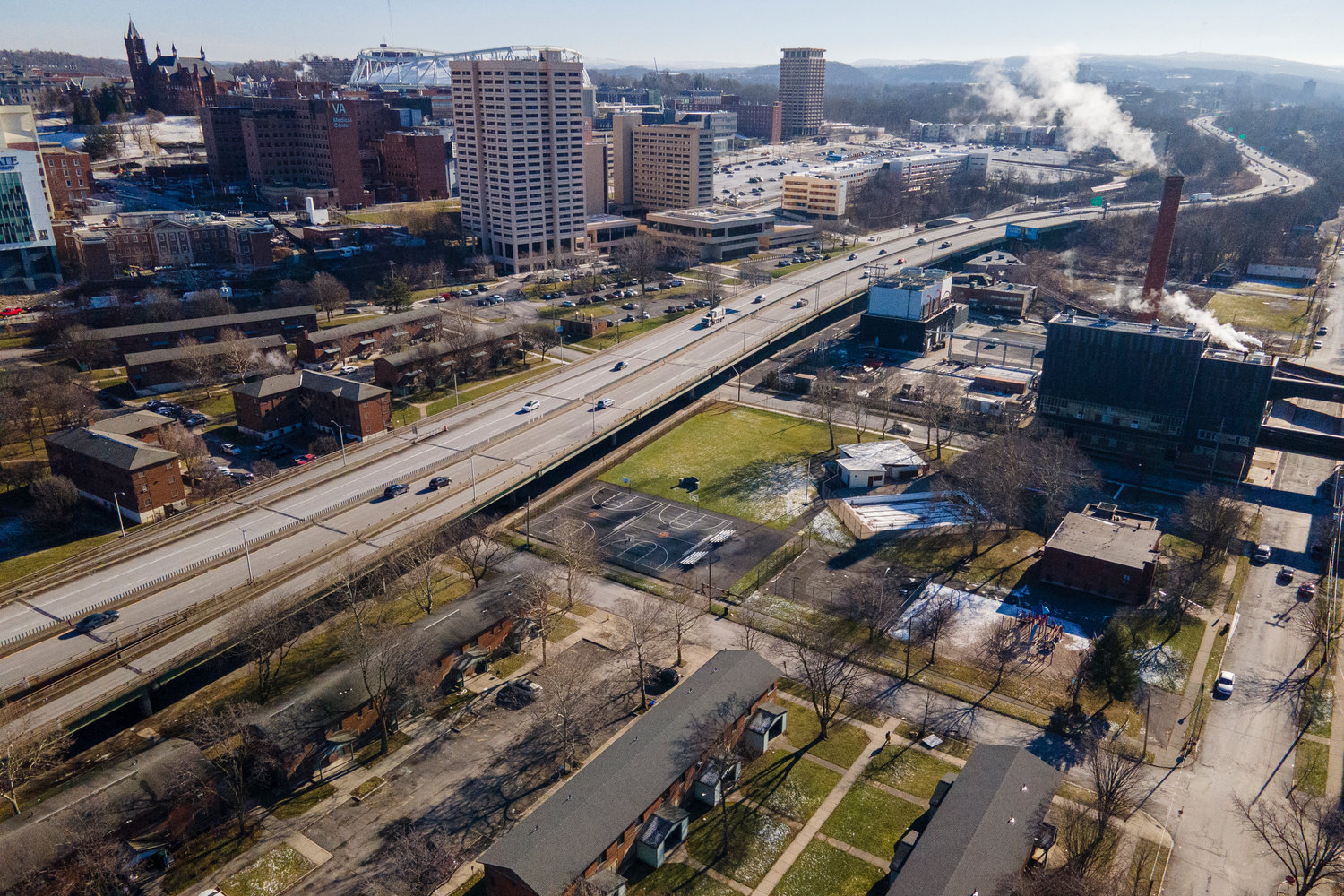 Interstate 81 passes through downtown Syracuse, N.Y., on Monday, Jan. 16, 2023. On the west side of the roadway are the Pioneer Homes public housing projects. Hospitals, hotels, Syracuse University buildings, and other structures are visible on the east side. (AP Photo/Ted Shaffrey)