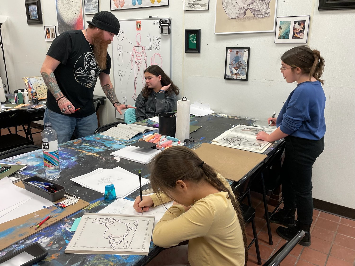 Art Instructor Steve Snegon, owner of E-98 Art Studio & Gallery, 5819 Rome-Taberg Road, Rome, provides young artists with some guidance on their art pieces at the studio.