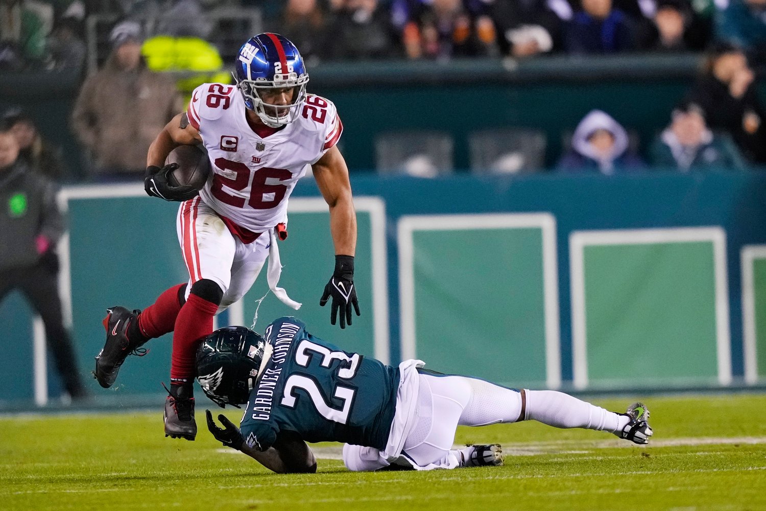 New York Giants running back Saquon Barkley (26) runs with the ball as Philadelphia Eagles safety C.J. Gardner-Johnson (23) tries to stop him during the second half of a divisional round playoff game on Saturday night in Philadelphia.