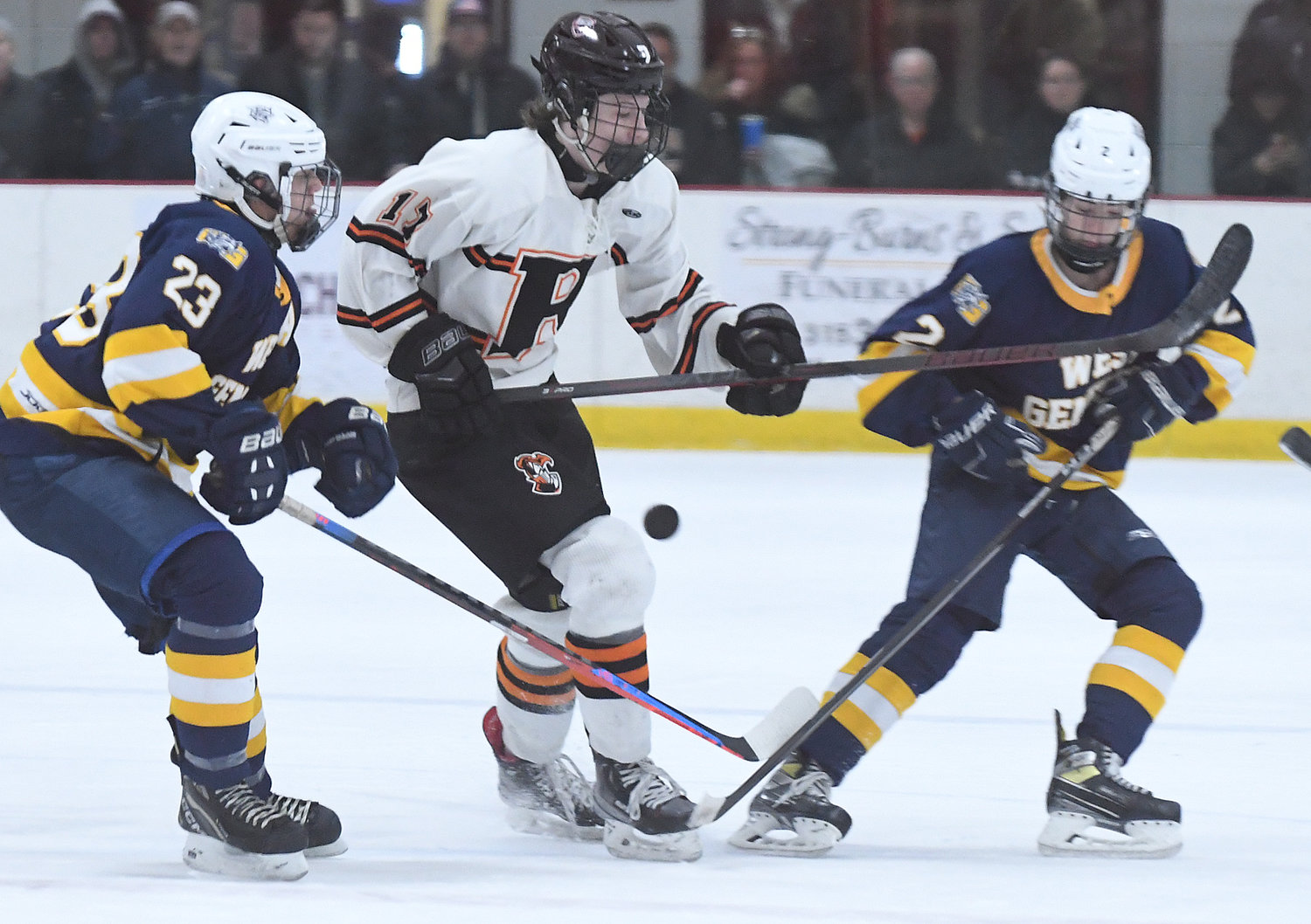 Jimmy Deangelo of Rome Free Academy, middle, looks to settle the puck in between West Genesee's Jack Mellen, left, and Christian Ball in the first period Tuesday night at Kennedy Arena. Mellen's two goals were part of team's offensive outpouring in a 10-1 win.