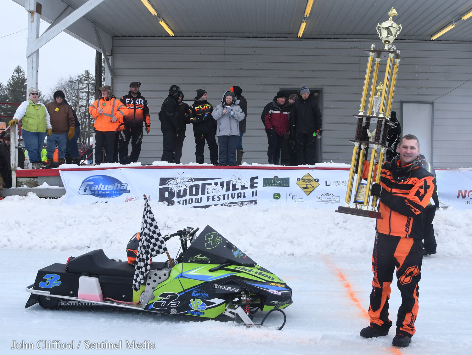 Jamie Bourgeois from Boonville is the 2023 Pro Champ Adirondack Cup winner holds up the massive trophy in victory lane Sunday, January 29.