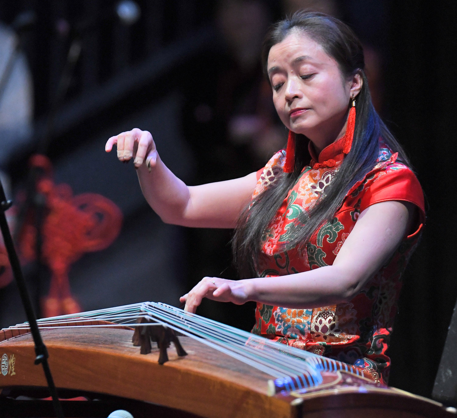 Daisy Wu of the Confucius Institute at Alfred University demonstrates the playing of a 21-string guzheng Friday, Feb. 3 in the Clinton Middle School auditorium.
