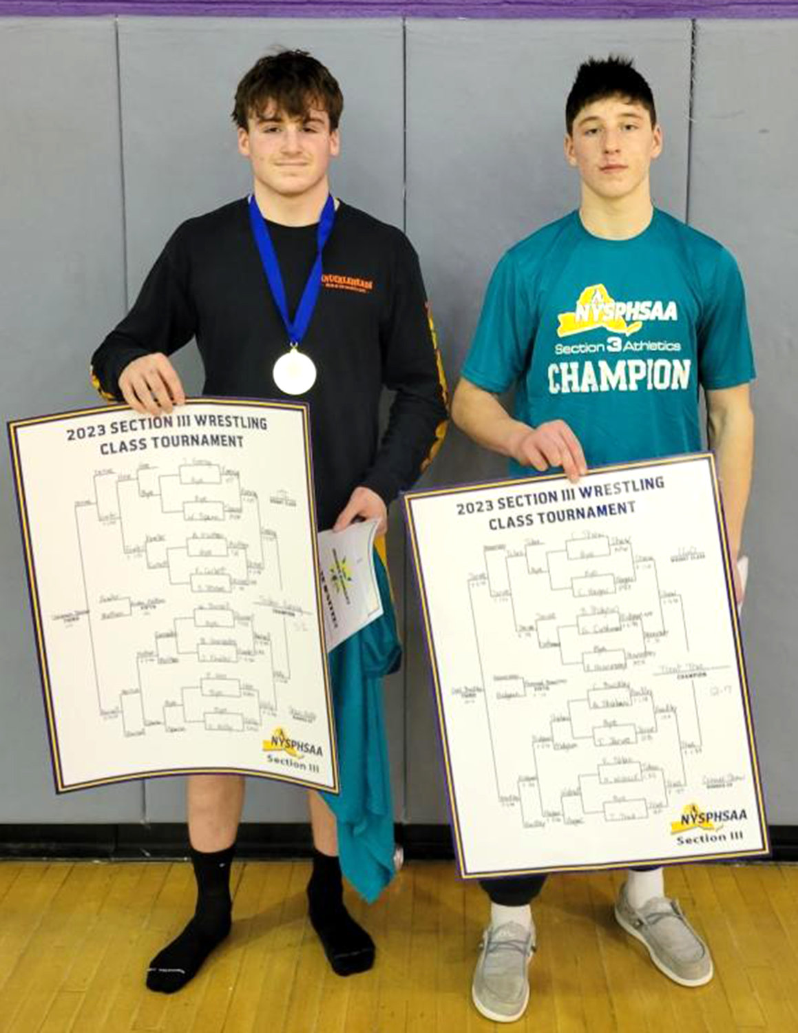 Holland Patent’s two Class C wrestling champions pose with their brackets this past weekend. Jordan Koenig, left, won the 172-pound weight class and Trent True won at 160 and was named the tournament’s Most Outstanding Wrestler. Both are among the local competitors taking part in this Saturday’s Section III tournament. Koenig is top-seeded and seeking a second trip to the state tournament. True is the two seed. Both are competing in Division II, the small schools division.