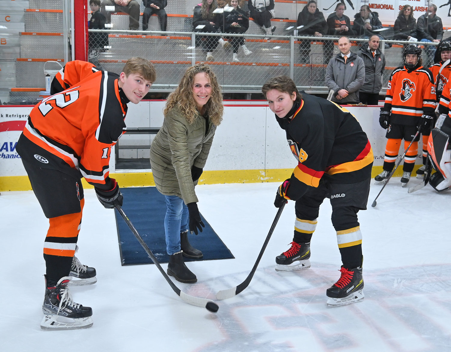 Lynn Mastracco, wife of Pete Mastracco, an RFA hockey assistant coach who died of colon cancer in August 2016, drops a ceremonial puck for the ninth annual Face Off against Colon Cancer game with RFA co-captain Jacob Premo, left, and Ontario Bay's Zach Blevins Tuesday night at Kennedy Arena. Premo scored twice and Blevins scored four times in Ontario Bay's 5-4 overtime win.