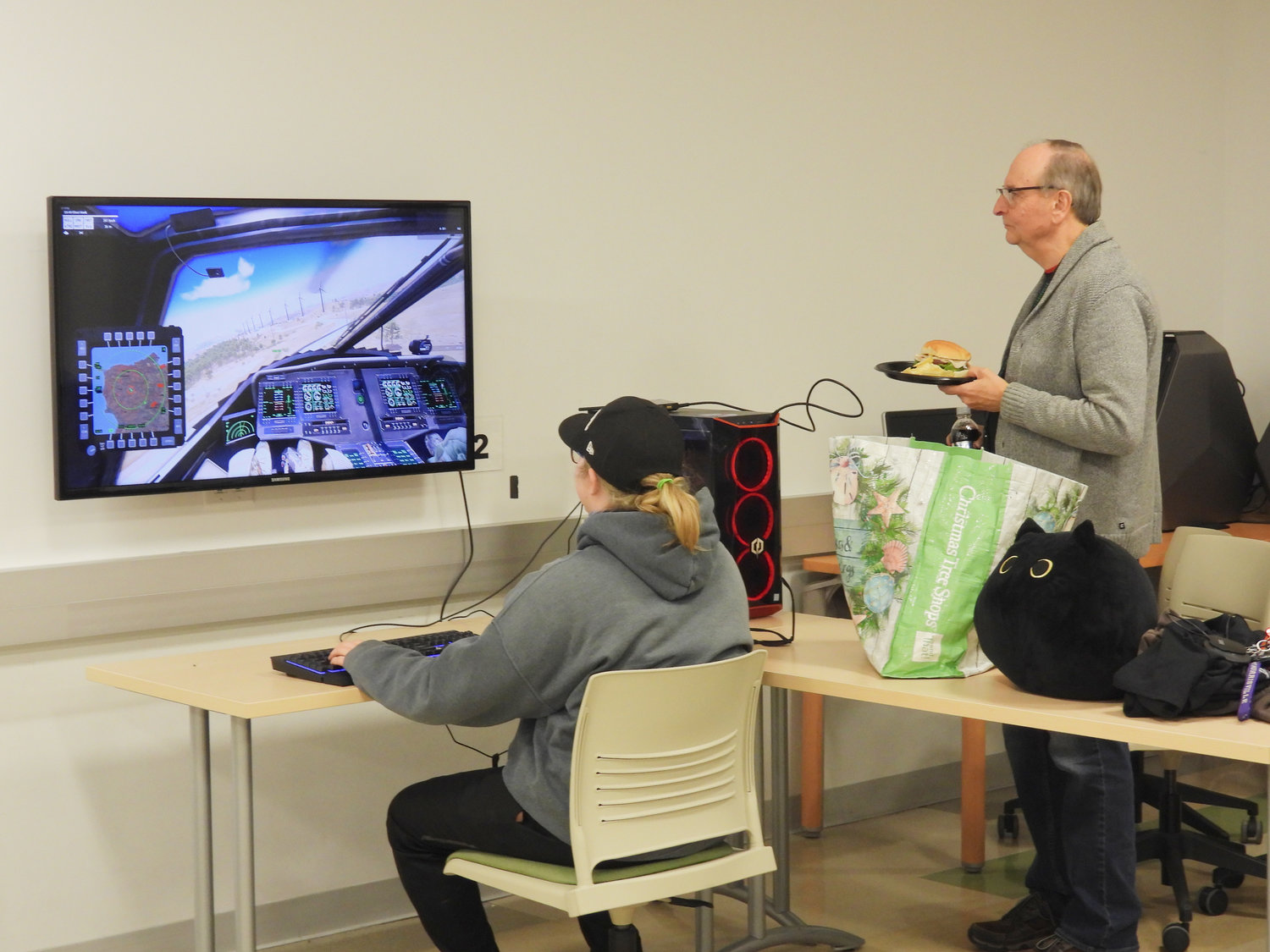 SUNY Morrisville Global Game Jam participant Grace Fowler, a freshman, takes a small break during lunch to show Professor Richard Marcoux one of her games at the Game Jam.
