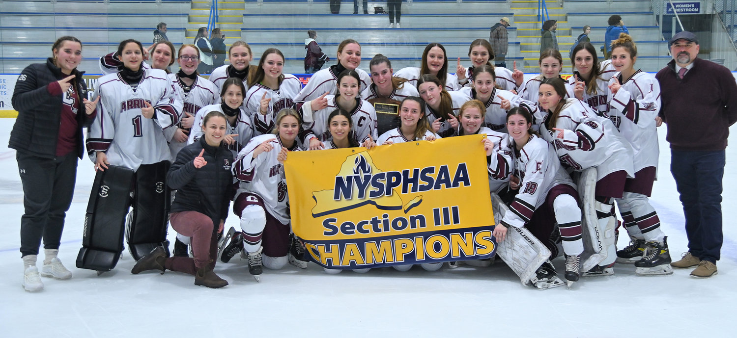 The Clinton Warriors celebrate their Section III girls ice hockey championship with their banner Wednesday night in Nedrow. The team beat Skaneateles 1-0 in overtime.
