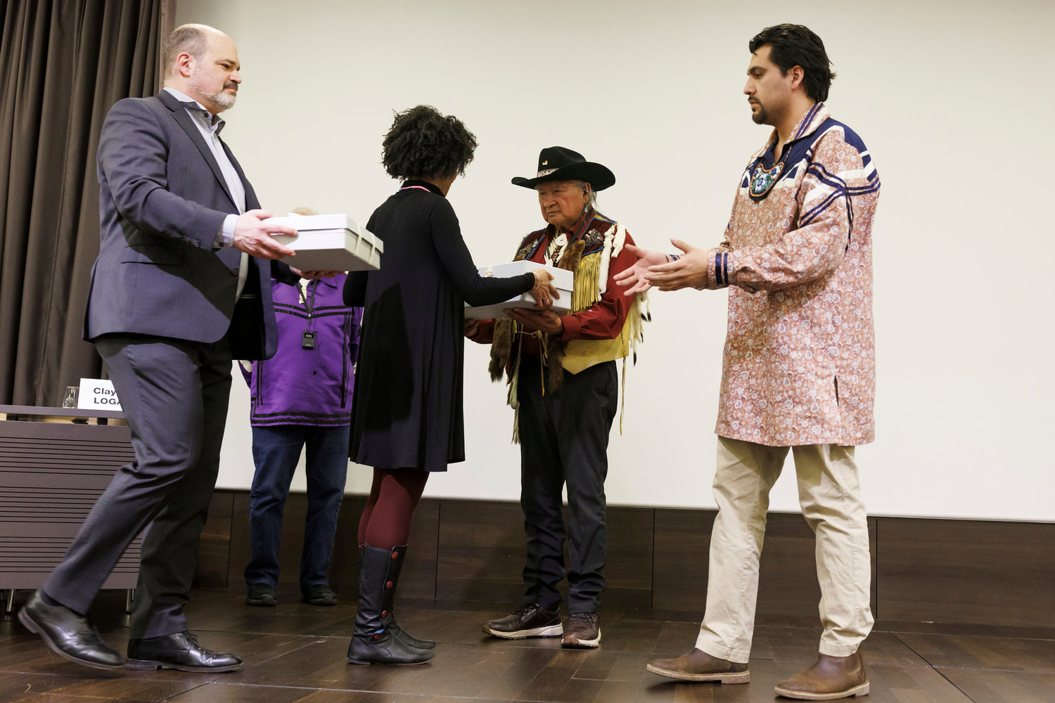 Sami Kanaan, left, Administrative Councillor of the City of Geneva, and Carine Ayele Durand, 2nd left, Director of the Museum of Ethnography of Geneva (MEG), give boxes containing sacred objects to representatives of Haudenosaunee Confederation Clayton Logan (Seneca Nation), 2nd right, and Brennen Ferguson (Tuscarora Nation), right, during the ceremony of restitution of sacred object to the Haudenosaunee Confederation, at the Museum of Ethnography of Geneva (MEG), in Geneva, Switzerland, Tuesday, February 7, 2023. The MEG has returned traditional sacred objects, a mask and a rattle, to the Haudenosaunee after 200 years in Switzerland. 

The Iroquois (/ˈɪrəkwɔɪ/ or /ˈɪrəkwɑː/), officially the Haudenosaunee (/ˌhoʊdinoʊˈʃoʊniː/[3][4] meaning "people who are building the longhouse"), are an Iroquoian-speaking confederacy of First Nations peoples in northeast North America/Turtle Island. They were known during the colonial years to the French as the Iroquois League, and later as the Iroquois Confederacy. The English called them the Five Nations, comprising the Mohawk, Oneida, Onondaga, Cayuga, and Seneca (listed geographically from east to west). After 1722, the Iroquoian-speaking Tuscarora people from the southeast were accepted into the confederacy, which became known as the Six Nations.