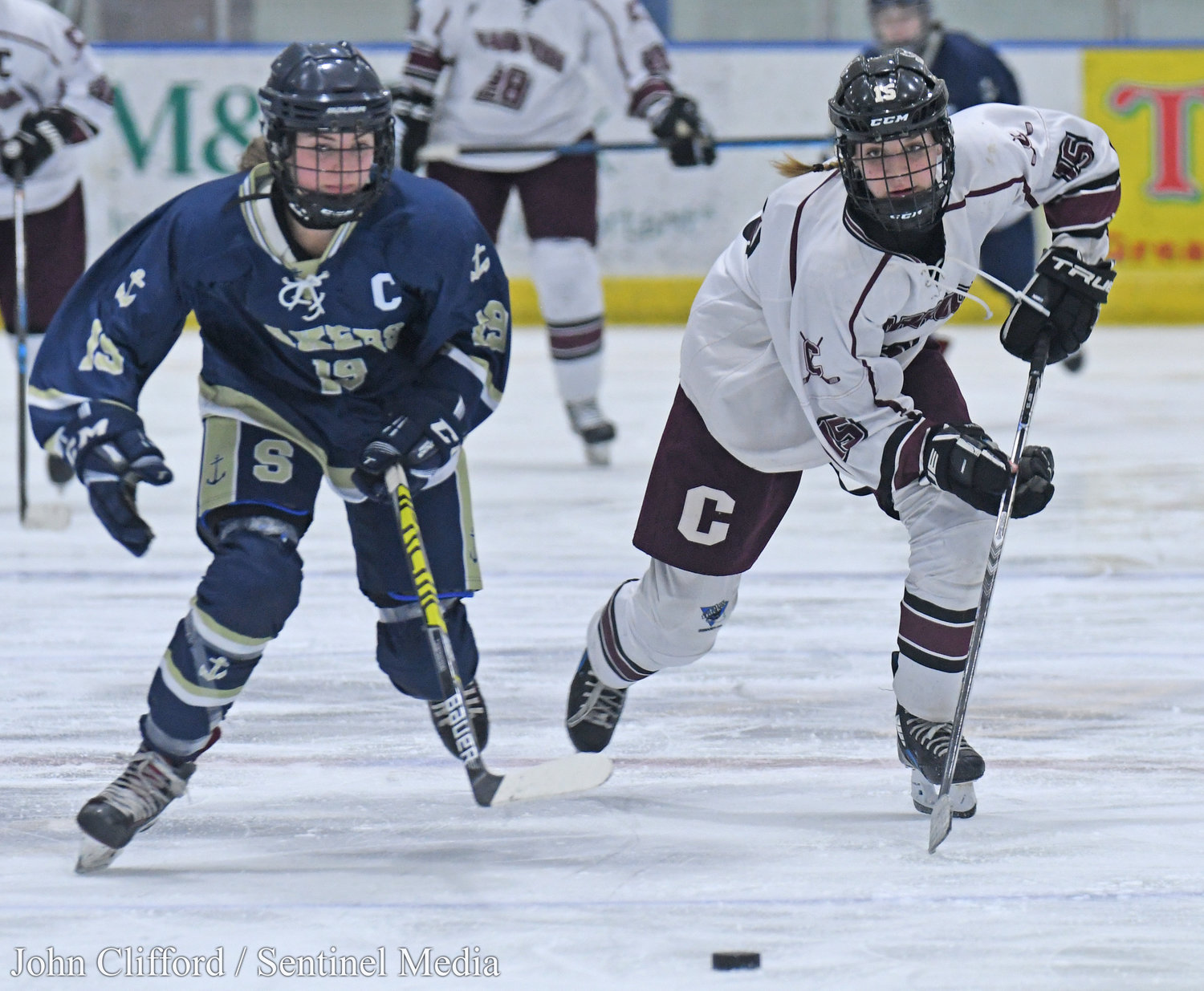 The Clinton Warriors in action against the Skaneateles Lakers in the Section III girls ice hockey championship Wednesday night in Nedrow. Clinton beat Skaneateles 1-0 in overtime. Lakers #19 and Clinton #15 chase the puck up the ice.