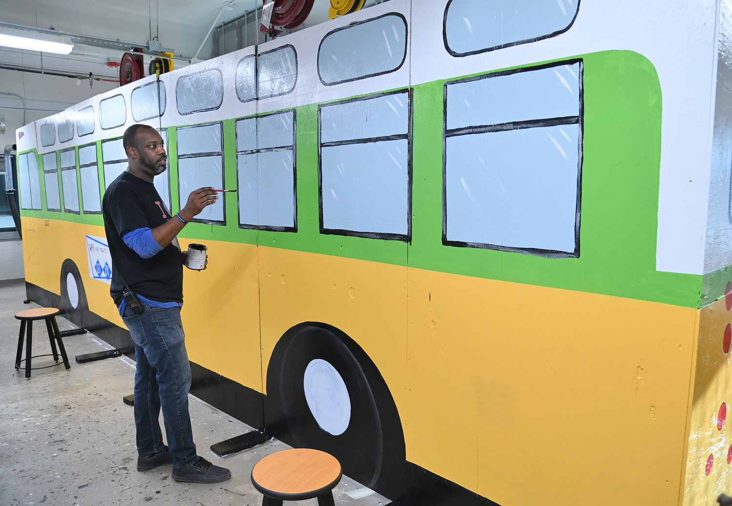 Student Support Specialist Grady Faulkner paints a replica of the famous Rosa Parks bus that will be displayed Feb 14 and 15 at Strough Middle School in Rome.