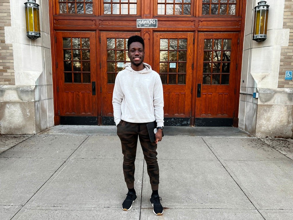Jerry Jean-Baptist stands in front of Hawkins Hall on the SUNY Plattsburgh campus. By Felicia Krieg