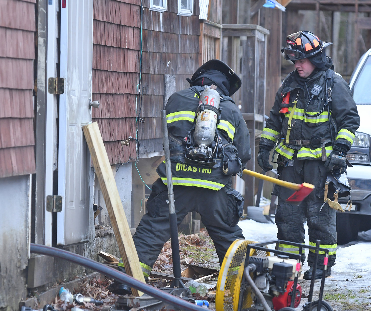 Rome Firefighter Marco J. DiCastro and Lt. Phillip J. Deihl use an axe to open up a basement window to evacuate smoke from a house fire at 309 N. Levitt St. Friday morning.