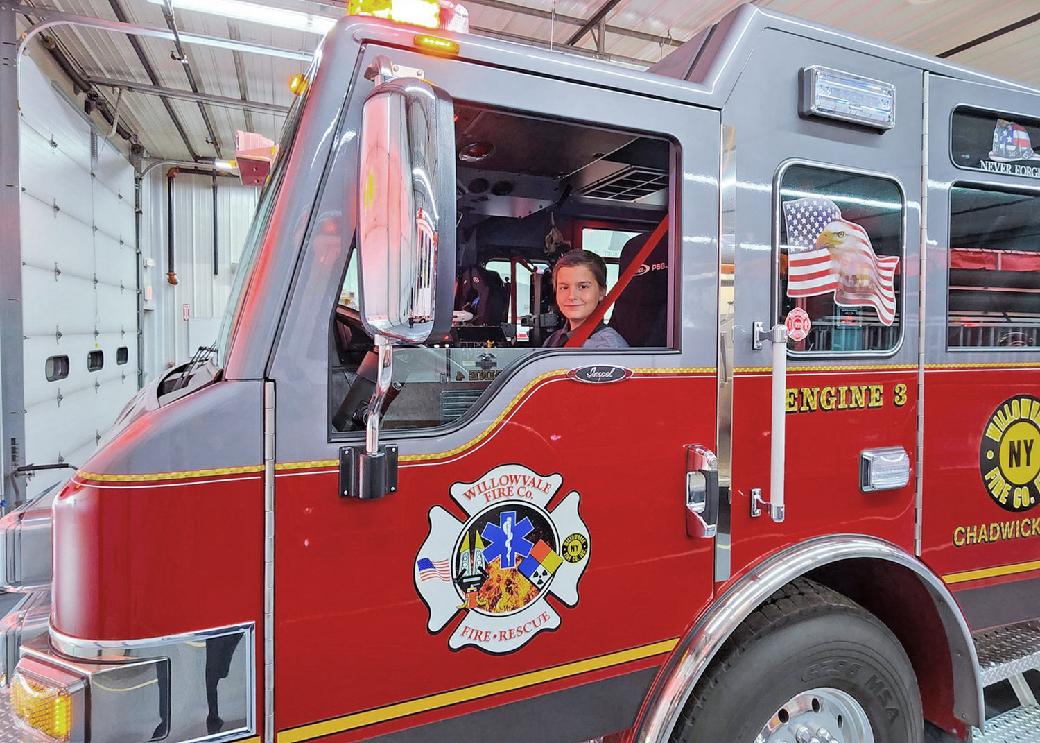 Carter Carro, age 11, poses inside a Willowvale Fire Department truck on Thursday.