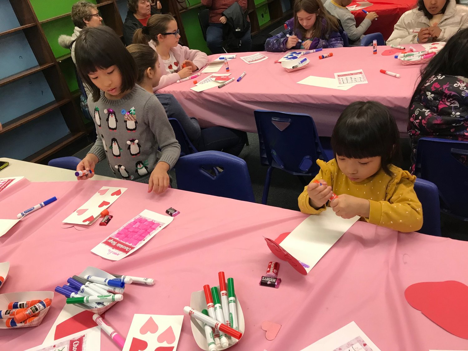 Anna Lisa Soe, left, and sister Victoria Soe work on their Valentine's Day crafts Saturday, Feb. 11 during a special children's program at the Utica Public Library.