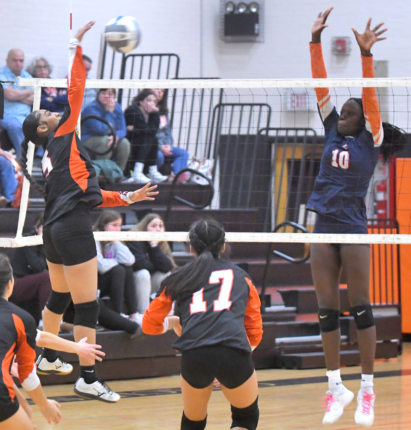 Kassity Cruz of Rome Free Academy, left, makes a kill in front of East Syracuse Minoa’s Akuot Kuany Friday night at Strough Middle School in Rome in a Class A quarterfinal match. Cruz had nine kills and 11 digs in a four-set win.