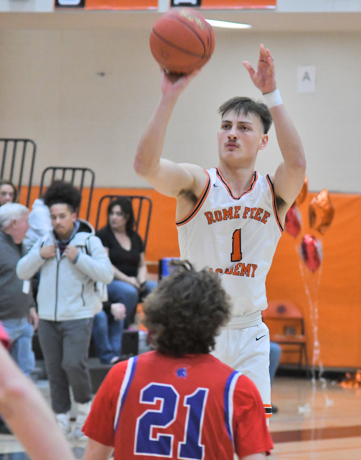 Rome Free Academy’s Jack Lawless shoots a three-pointer with New Hartford’s Dan MacTurk defending Tuesday night at RFA. Lawless had 12 points and nine rebounds in RFA’s 62-50 win.