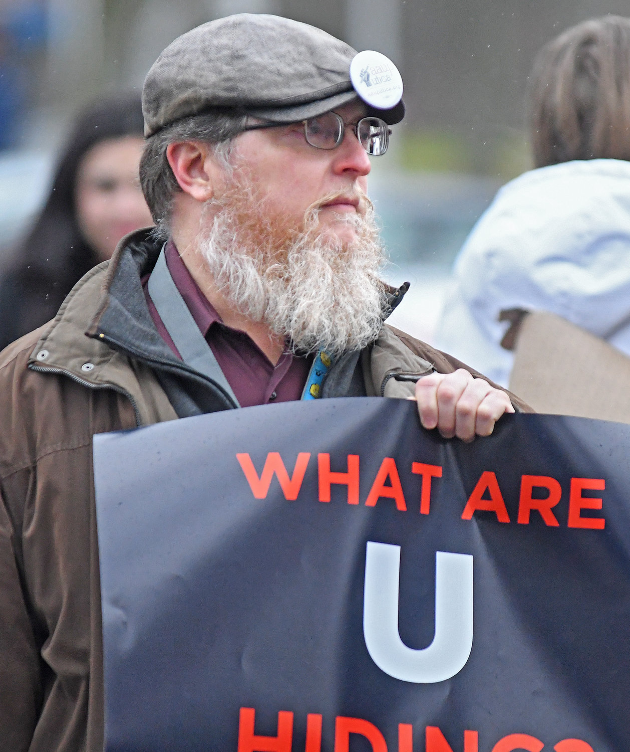 Mathematics Professor Andrew Reeves holds a sign during a protest Friday, Feb. 17 at Utica University.