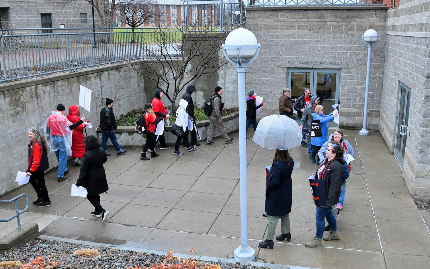 Protesters parade by the Bull Family Board Room Friday, Feb 17 at Utica University.