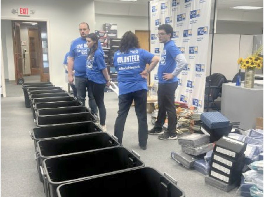 Volunteers get ready to transform empty black plastic bins into festive Welcome Home Kits, complete with a variety of supplies and materials such as cookware, towels and bedding for individuals and families who were previously unhoused or living in shelters as they secure a home.