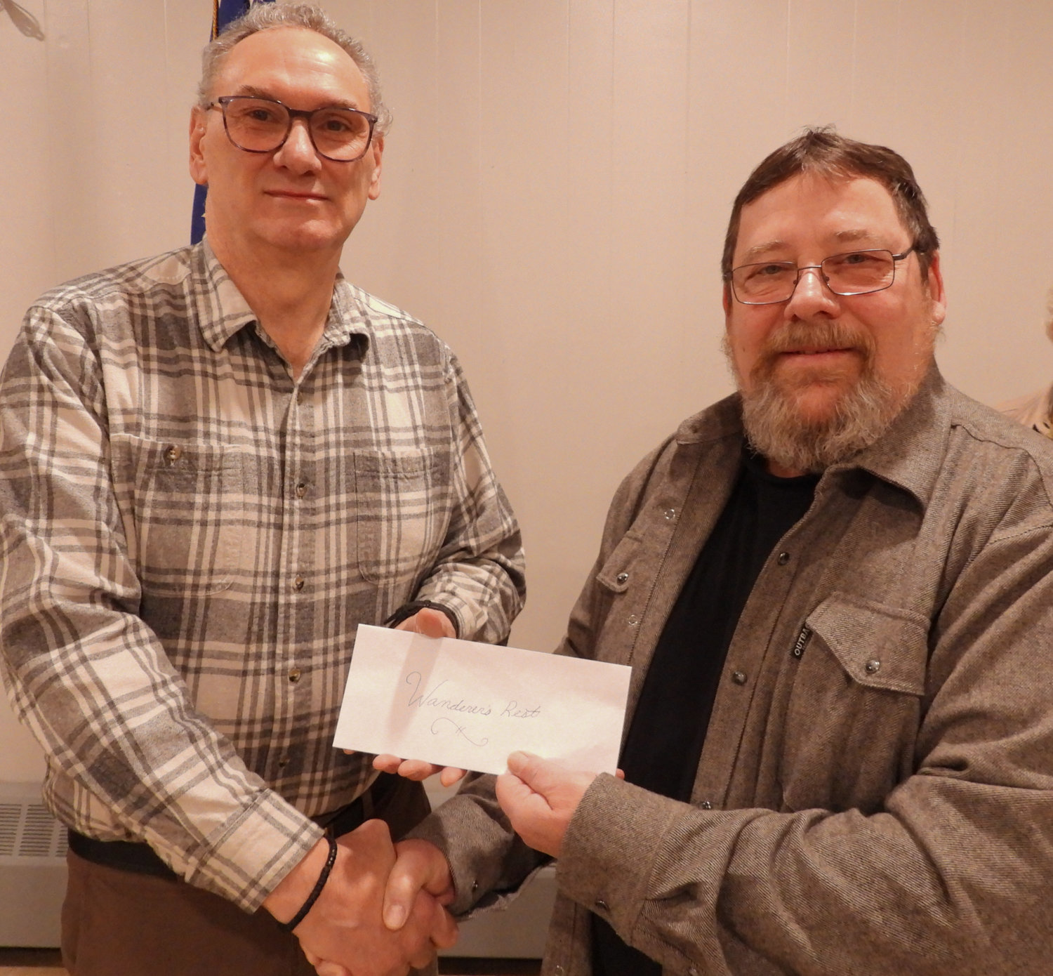 Wanderers' Rest Board President Lewis Carinci, left, shakes hands and receives a check for $2,000 from Owlâs Nest President John Smoyer on Monday, Fe