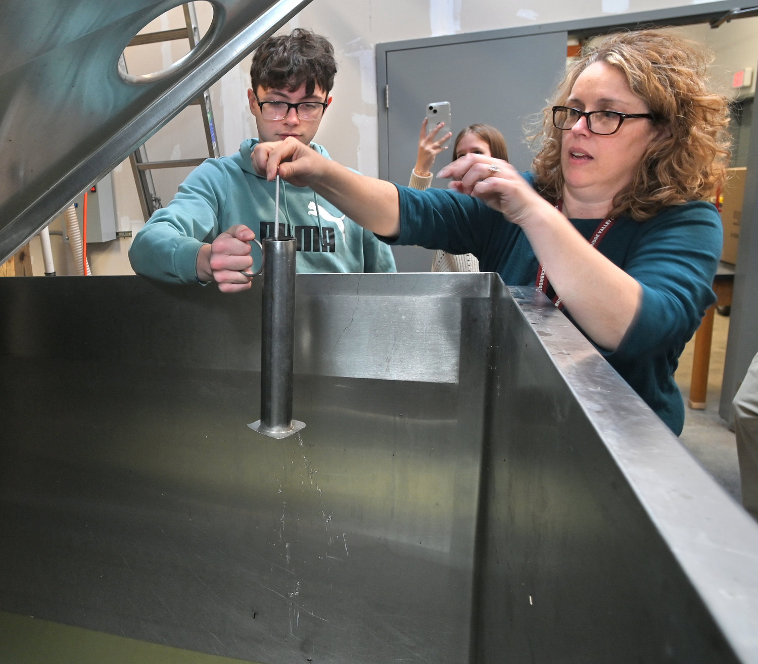Stockbridge Valley Central School 10th grader Hayden Dye, left, and his agriculture teacher and FFA co-advisor Erin Smith check a hydrometer reading of the sap that has been collected Wednesday, Feb. 15 in the Munnsville school’s sap house.