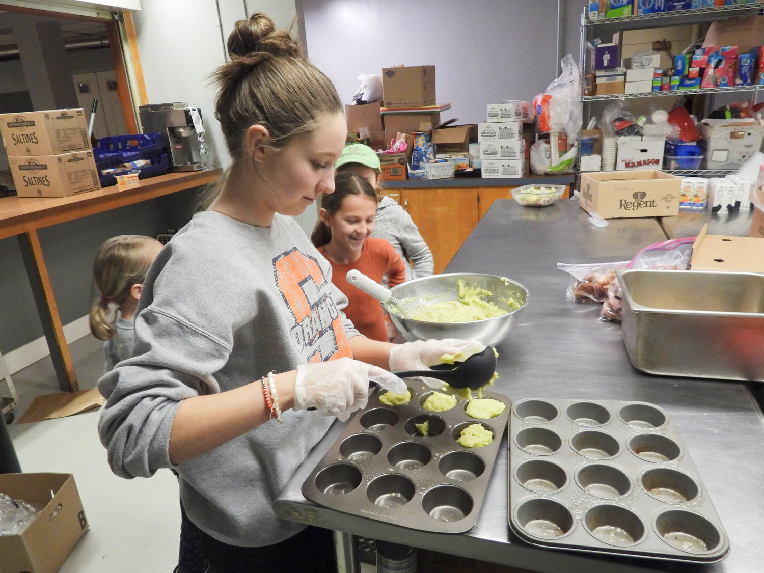 Youth volunteers from Our Lady of Good Counsel in Verona work to assemble meals at Karing Kitchen on Thursday, Feb. 23. Pictured is Kaitlyn Grems, 13, of Durhamville, who attends Holy Cross Academy. Students are currently on mid-winter vacation