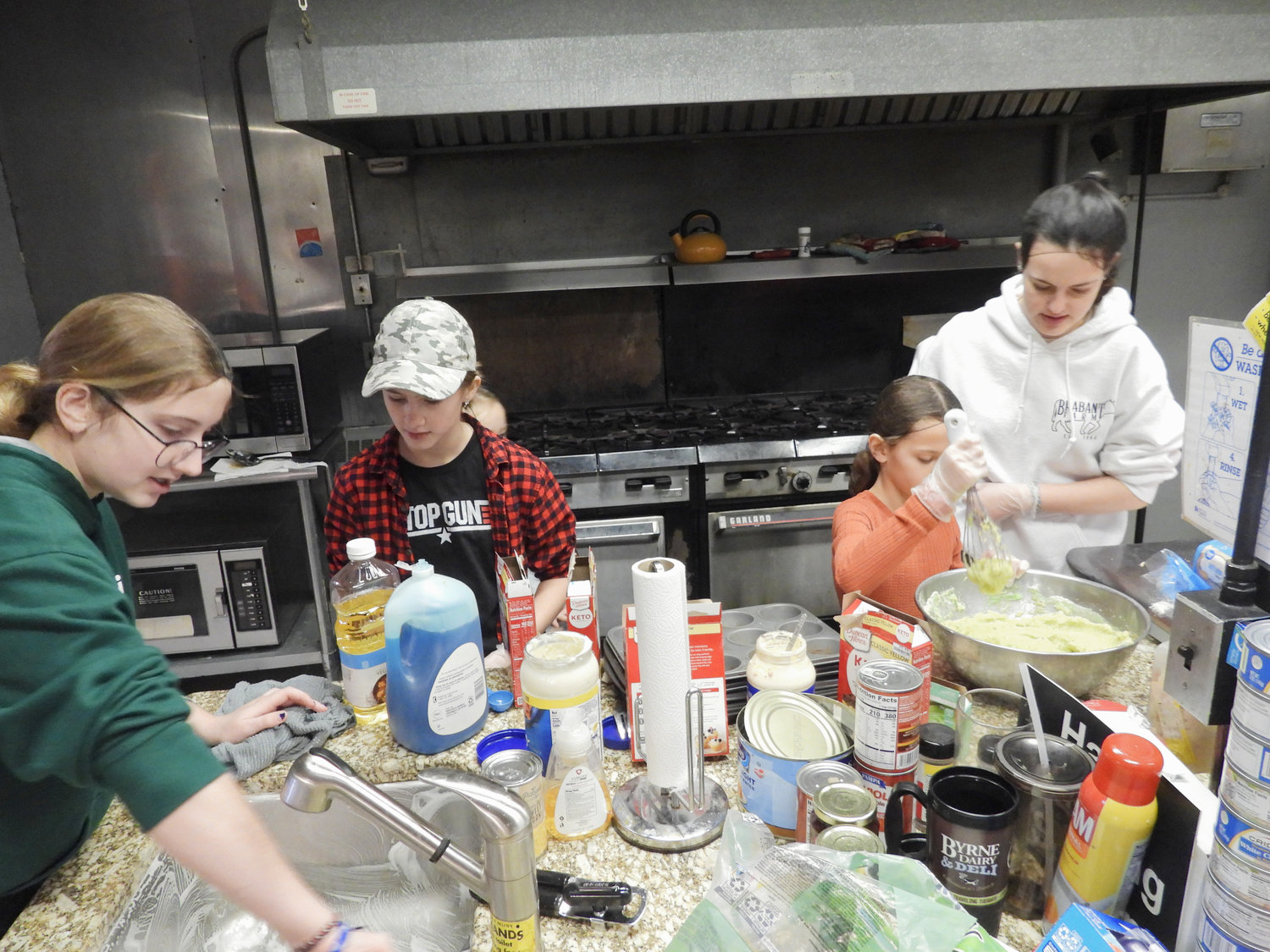 Youth volunteers from Our Lady of Good Counsel in Verona work to assemble meals at Karing Kitchen on Thursday.