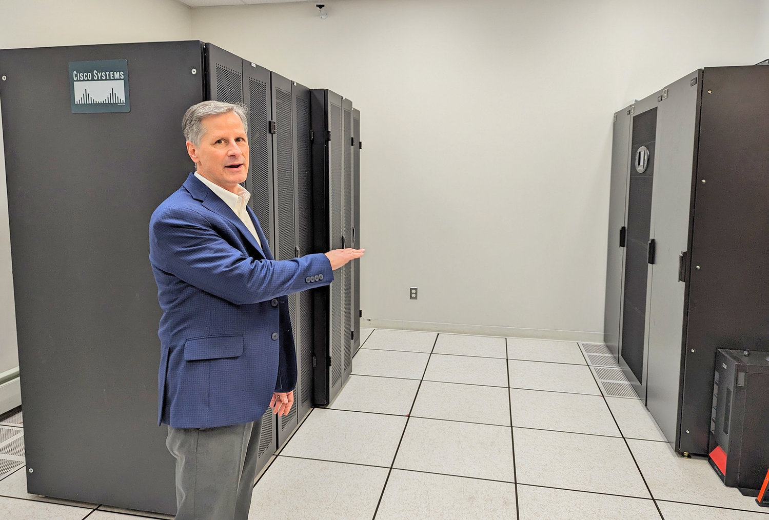 Michael Polce, owner and CEO of M.A. Polce Consulting, shows off his in-house servers and computer power at his office at the Griffiss and Business Technology Park in Rome.