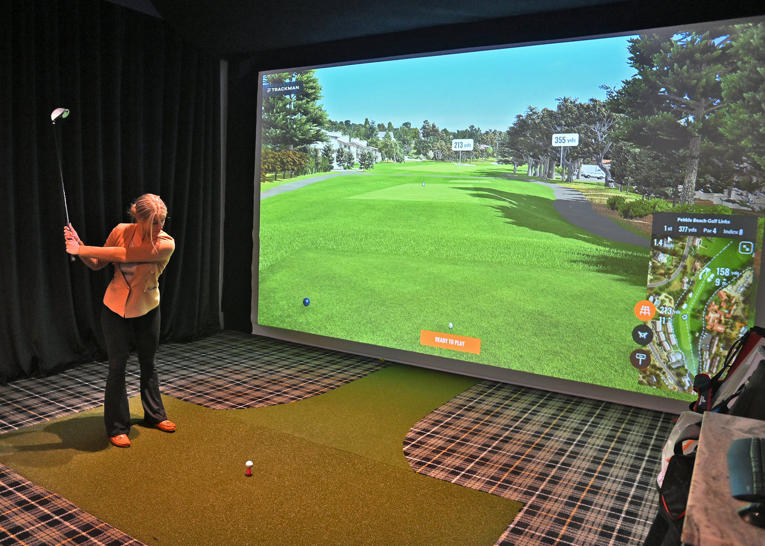 Rachele Potaczala, general manager at The Bunker Bar &amp; Grill at 8653 Clinton St. in New Hartford, demonstrates one of the suites that guests can play rounds of golf in.