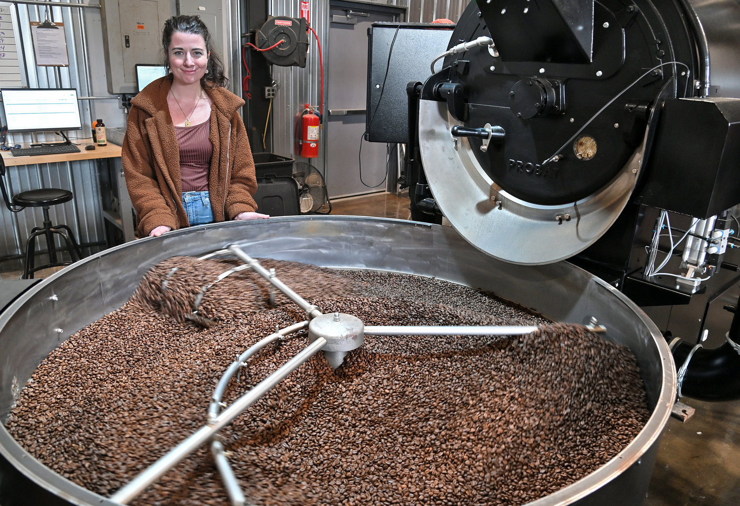 India Pachal at the cooling tray after coffee beans were roasted by the coffee roasting machine at Utica Coffee Roasting Inc. in Utica.