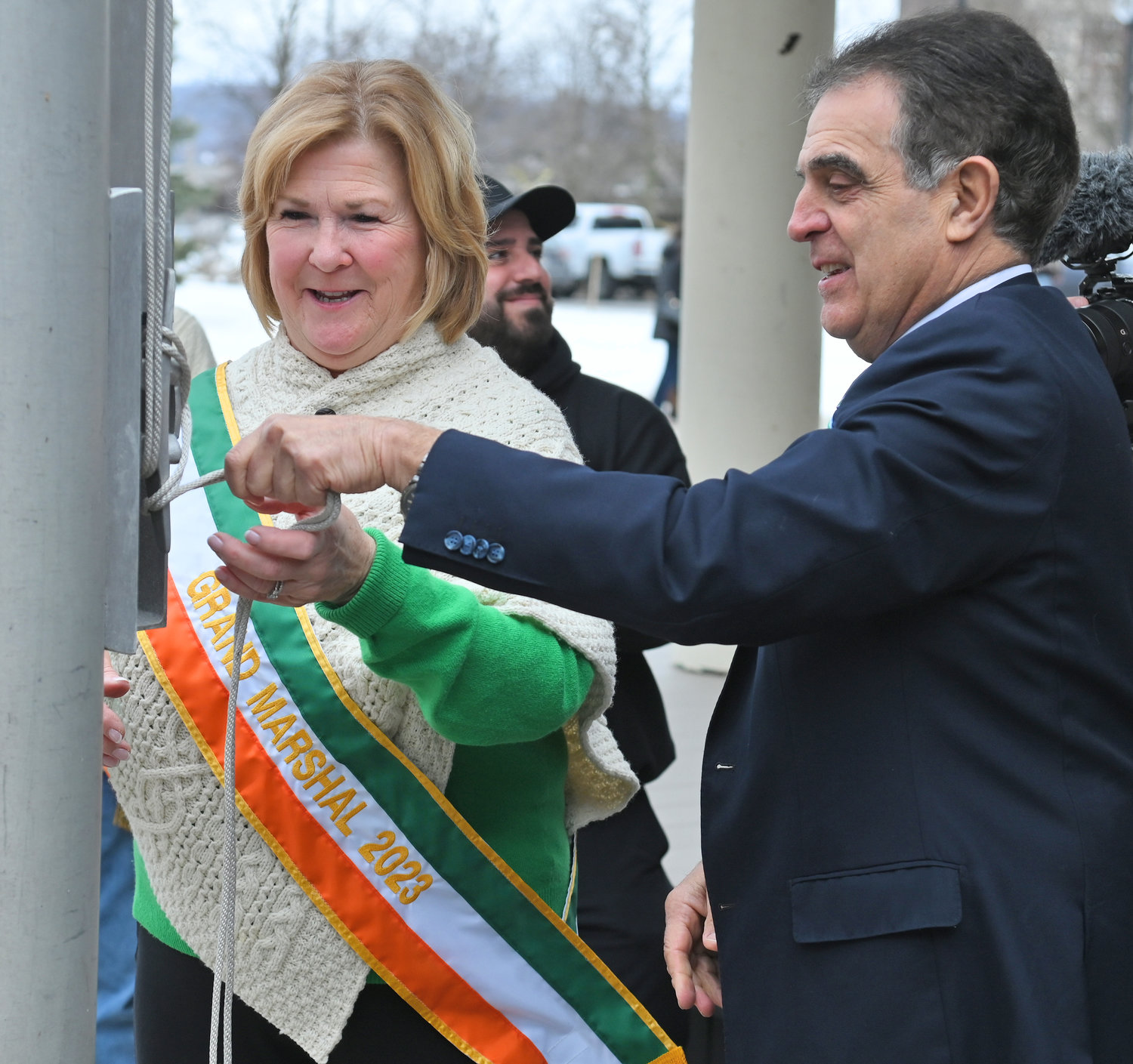 ALL SECURE — Utica St. Patrick’s Day Parade Grand Marshal Colleen Kain Martin and Mayor Robert Palmieri secure the rope used to raise the Irish flag over city hall on Wednesday.