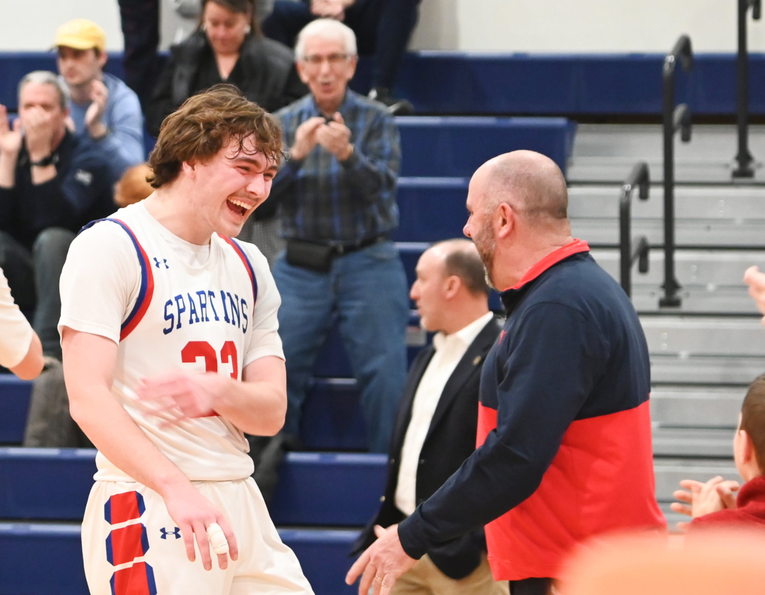 New Hartford senior Zack Philipkoski celebrates with coach John Randall following the team's 69-60 victory over Troy on Wednesday at Liverpool High School. New Hartford advances to play in a regional final on Saturday at SUNY Potsdam.