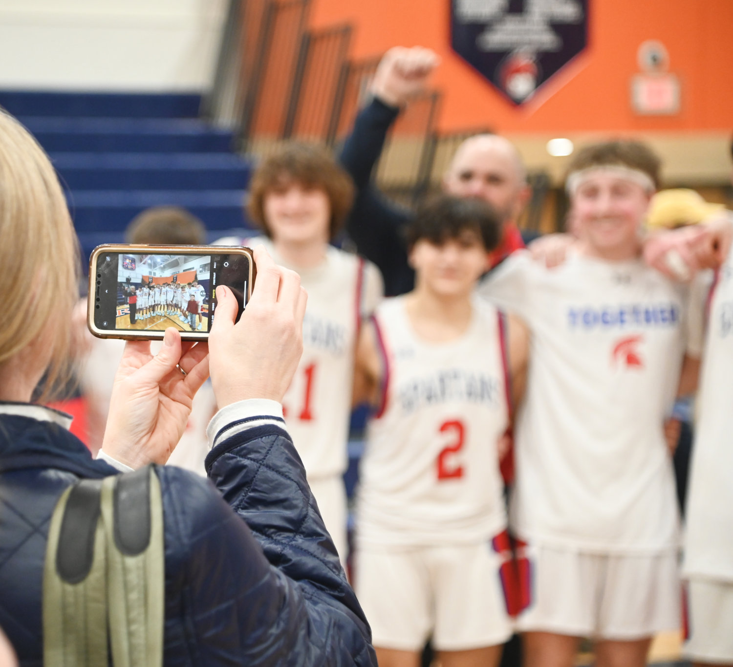 A New Hartford fan snaps a photo following the team's 69-60 win over Troy in the Class A subregional final on Wednesday at Liverpool High School.