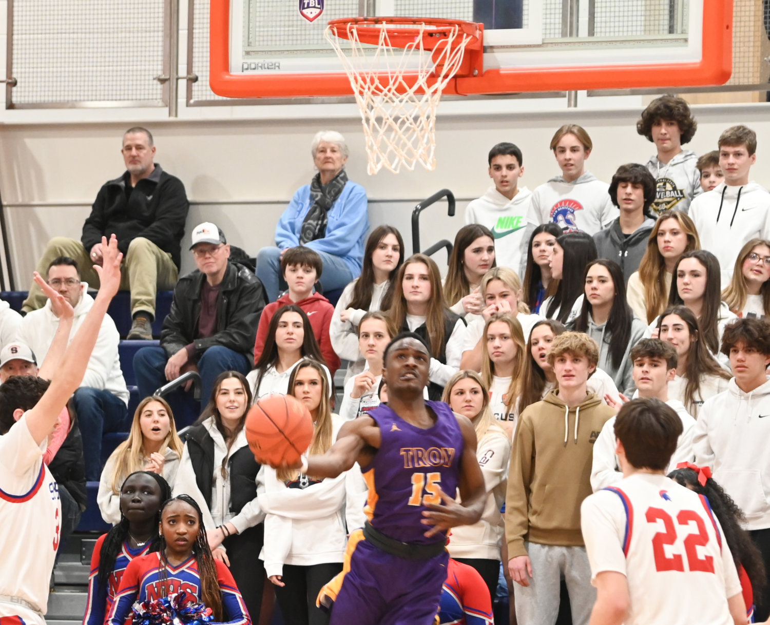 Troy's Damarian Tucker makes a nifty move to the basket against New Hartford on Wednesday in a Class A subregional final at Liverpool High School. New Hartford fans look on.