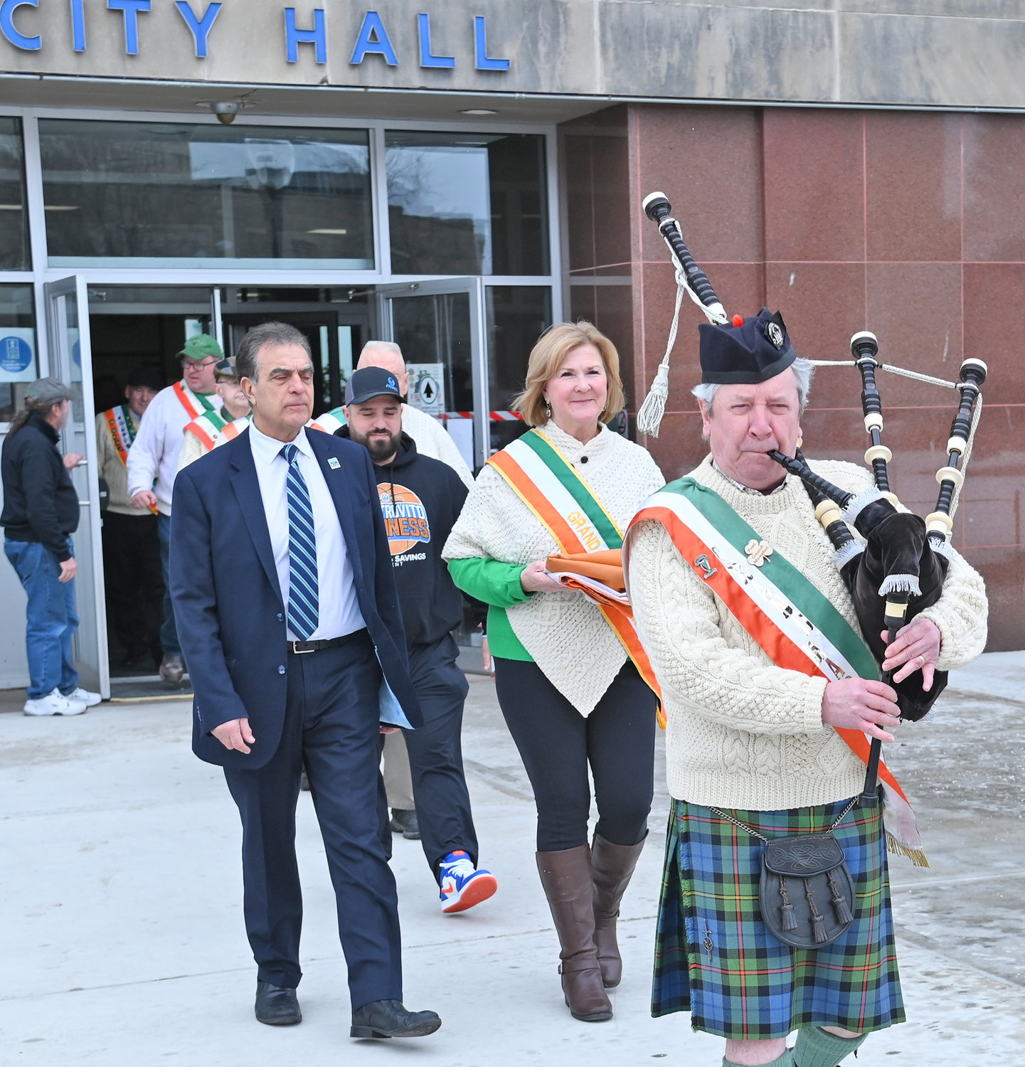 Bagpiper Dr. Daniel Murphy leads Mayor Robert Palmieri and Colleen Kain Martin, the grand marshal of the upcoming St. Patrick’s Day Parade in Utica, as they head out of Utica City Hall and toward the flag pole as they prepare to hoist the Irish flag on Wednesday afternoon.