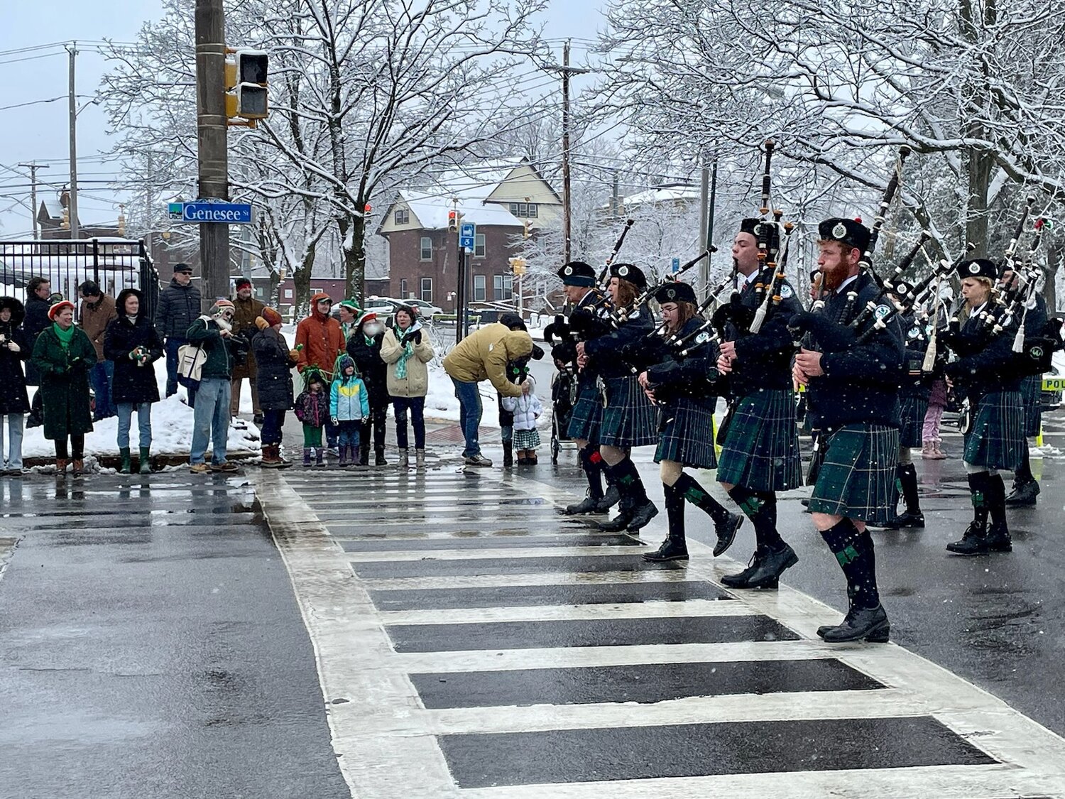 A crowd of spectators take in all the festivities as bagpipers make their way down Genesee Street in Utica's St. Patrick's Day Parade on Saturday.
