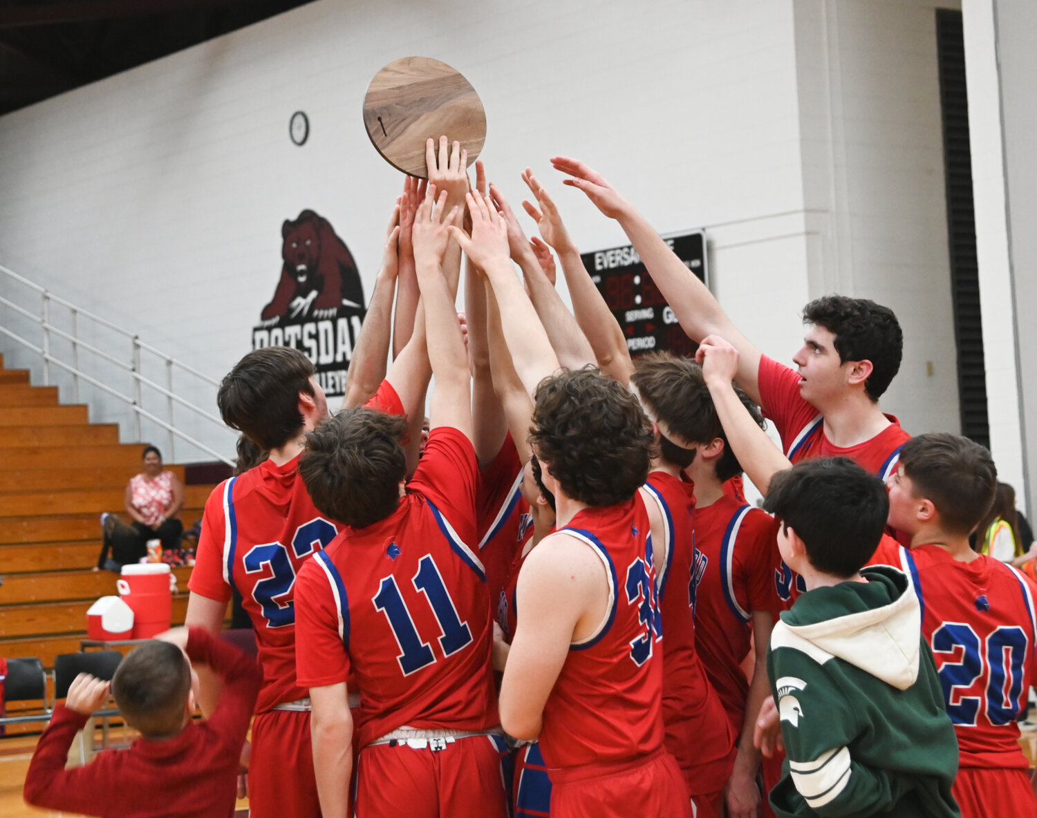 The New Hartford boys basketball team celebrates with the the trophy for winning the Class A regional final on Saturday afternoon at SUNY Potsdam. New Hartford is back in the state Class A final four for the second time in as many years.