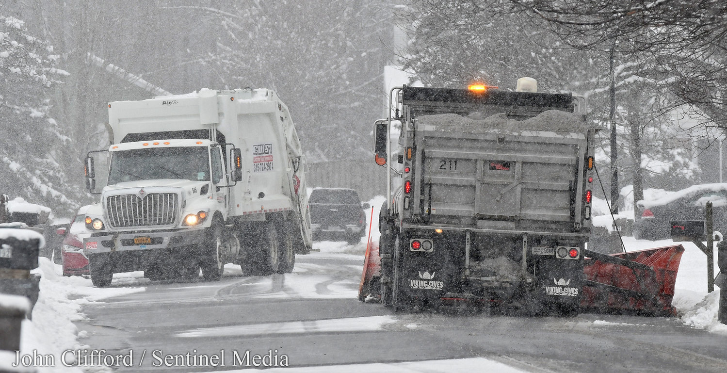 A CWSI garbage truck makes way for a city plow on Cedarwood Dr. Tuesday, March 14, 2023.