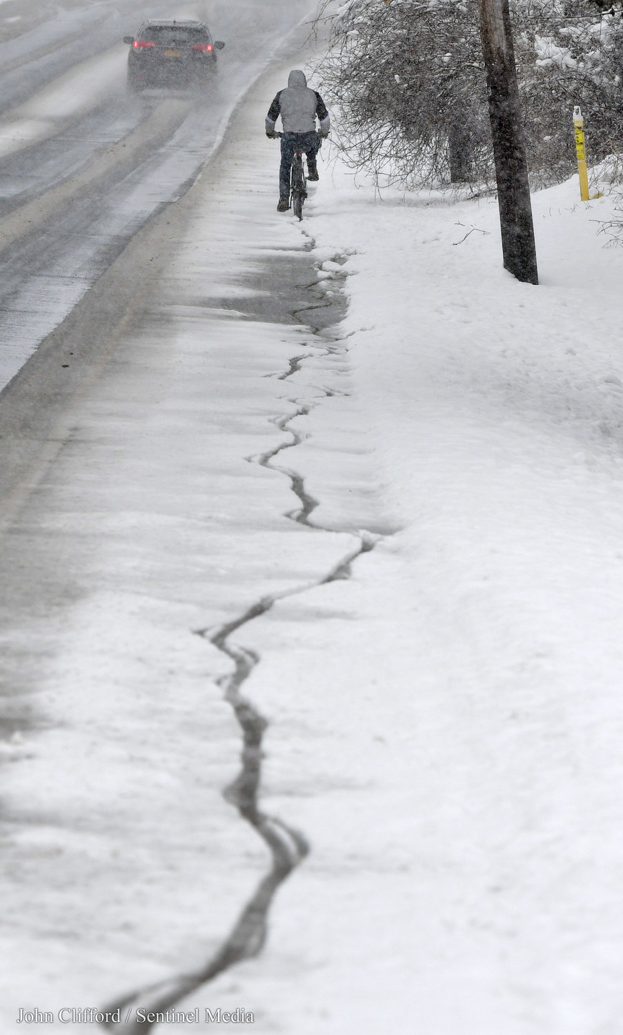 A bicyclist makes his way north on Turin St. near the former Beeches property Tuesday, March 14, 2023.