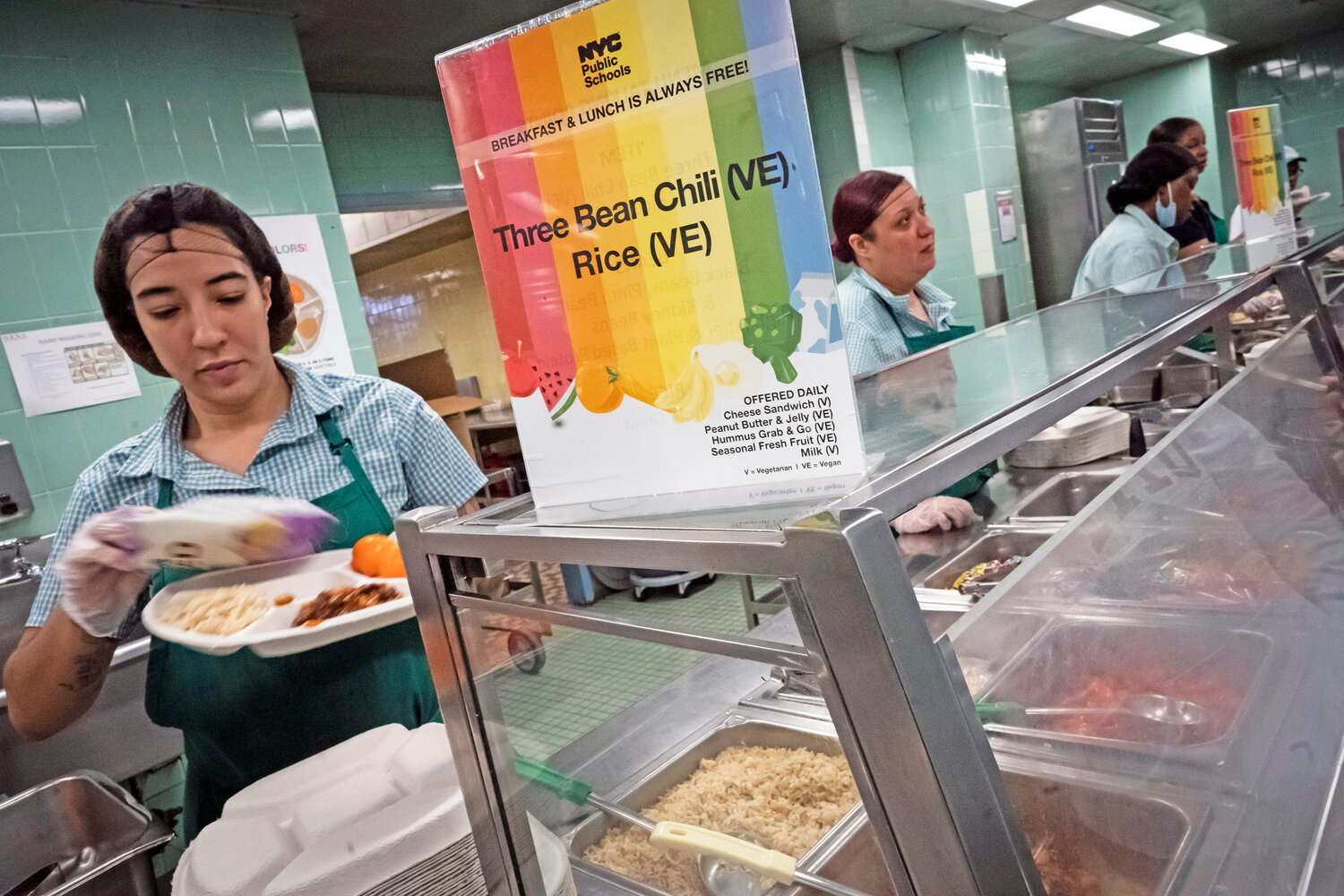 Cafeteria staff serve lunch to 7th graders during their lunch break at a public school, Saturday, Feb. 11, 2023, in the Brooklyn borough of New York.