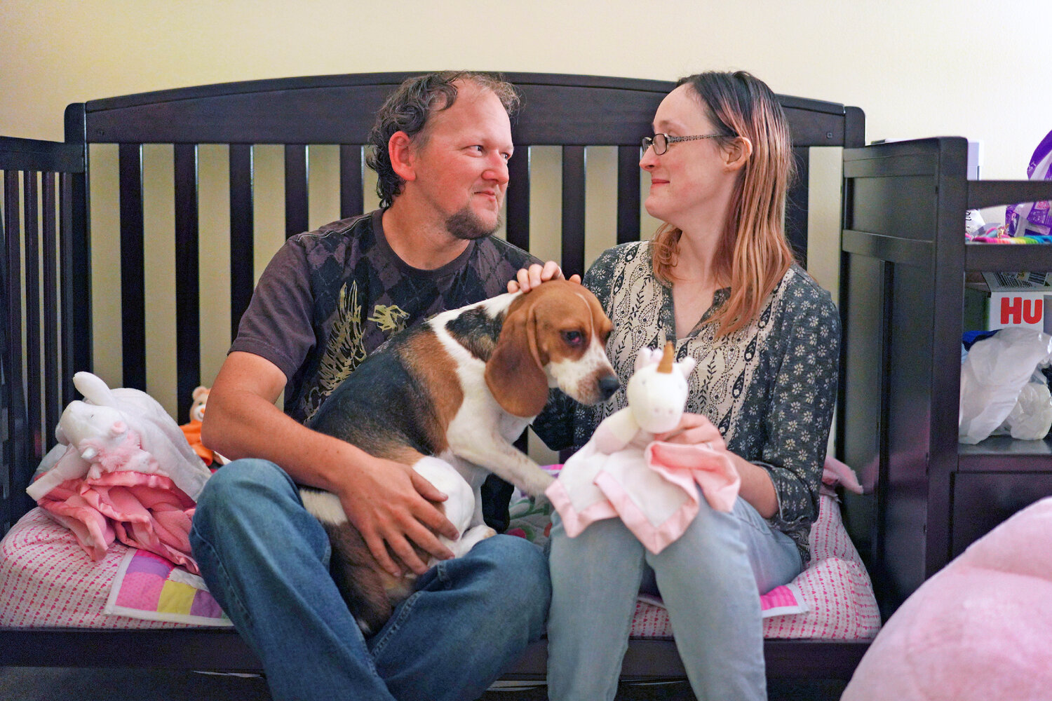 Andrew and Lauren Hackney sit in their daughter's room with their dog Scrappy after one of their twice-weekly supervised visits, in Oakdale, Pa., on Thursday, Nov. 17, 2022. At 7 months old, the couple had difficulty feeding their daughter and brought her to the children's hospital in Pittsburgh. They believe hospital staff alerted the Allegheny County Department of Human Services because the baby was severely dehydrated and malnourished, which resulted in removing the young child from their custody. The Hackneys and their lawyer believe the Allegheny County Family Screening tool may have flagged the couple as dangerous because of their disabilities. Over a year later, they continue to fight for custody of their child.