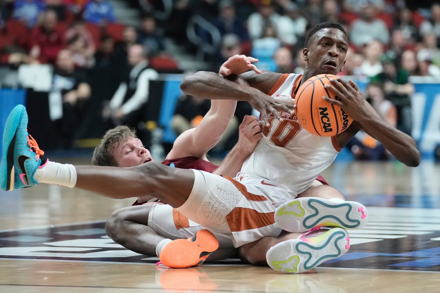 Sir'Jabari Rice, of Texas, and Colgate's Tucker Richardson battle for a loose ball during the second half of a first-round NCAA Tournament game on Thursday night in Des Moines, Iowa. Rice scored 23 points and No. 2 seed Texas shut down sharpshooting Colgate for an 81-61 victory.