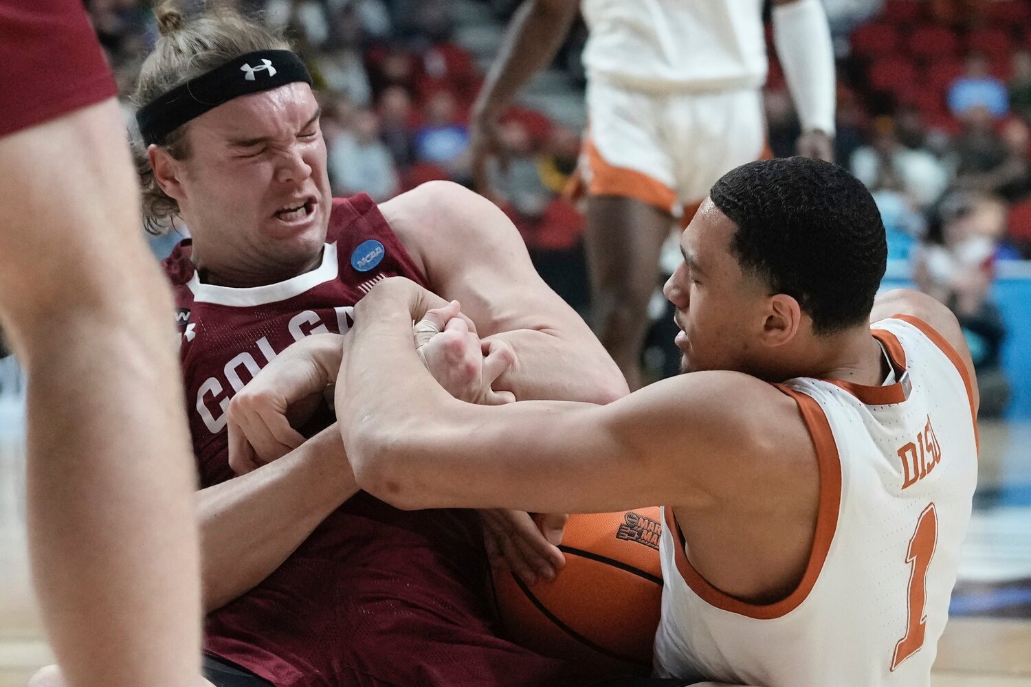 Texas's Dylan Disu and Colgate's Keegan Records battle for a loose ball during the first half of a first-round NCAA Tournament game on Thursday night in Des Moines, Iowa.