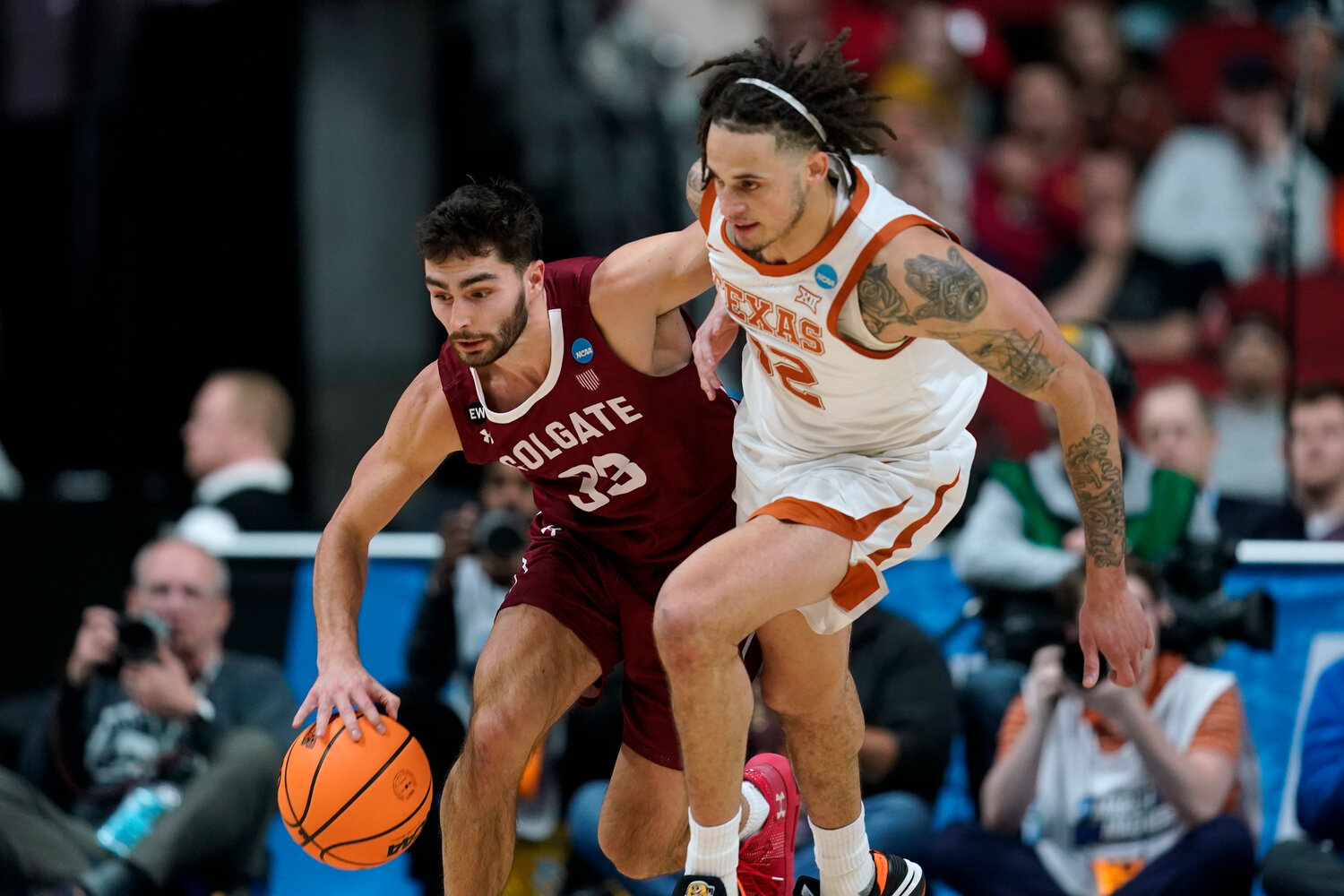 Colgate guard Oliver Lynch-Daniels (33) drives up court past Texas forward Christian Bishop (32) in the first half of a first-round NCAA Tournament game against Texas on Thursday night in Des Moines, Iowa.