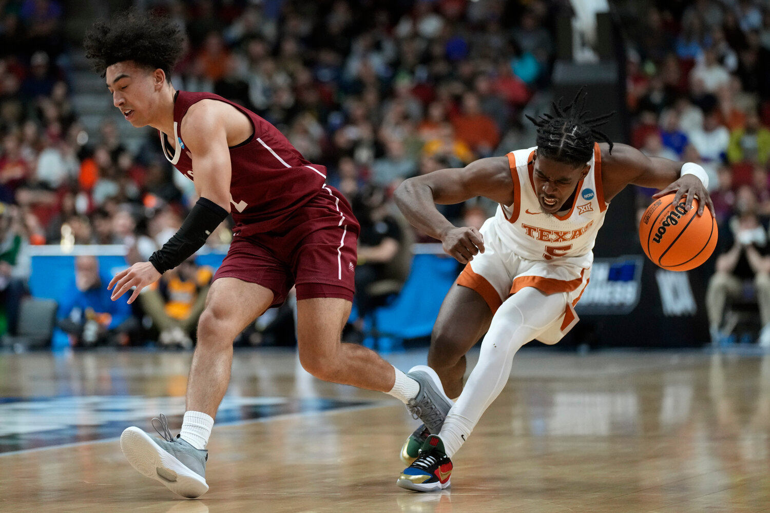 Texas guard Marcus Carr (5) drives up court past Colgate guard Braeden Smith, left, in the second half of a first-round NCAA Tournament game against Texas on Thursday night in Des Moines, Iowa.