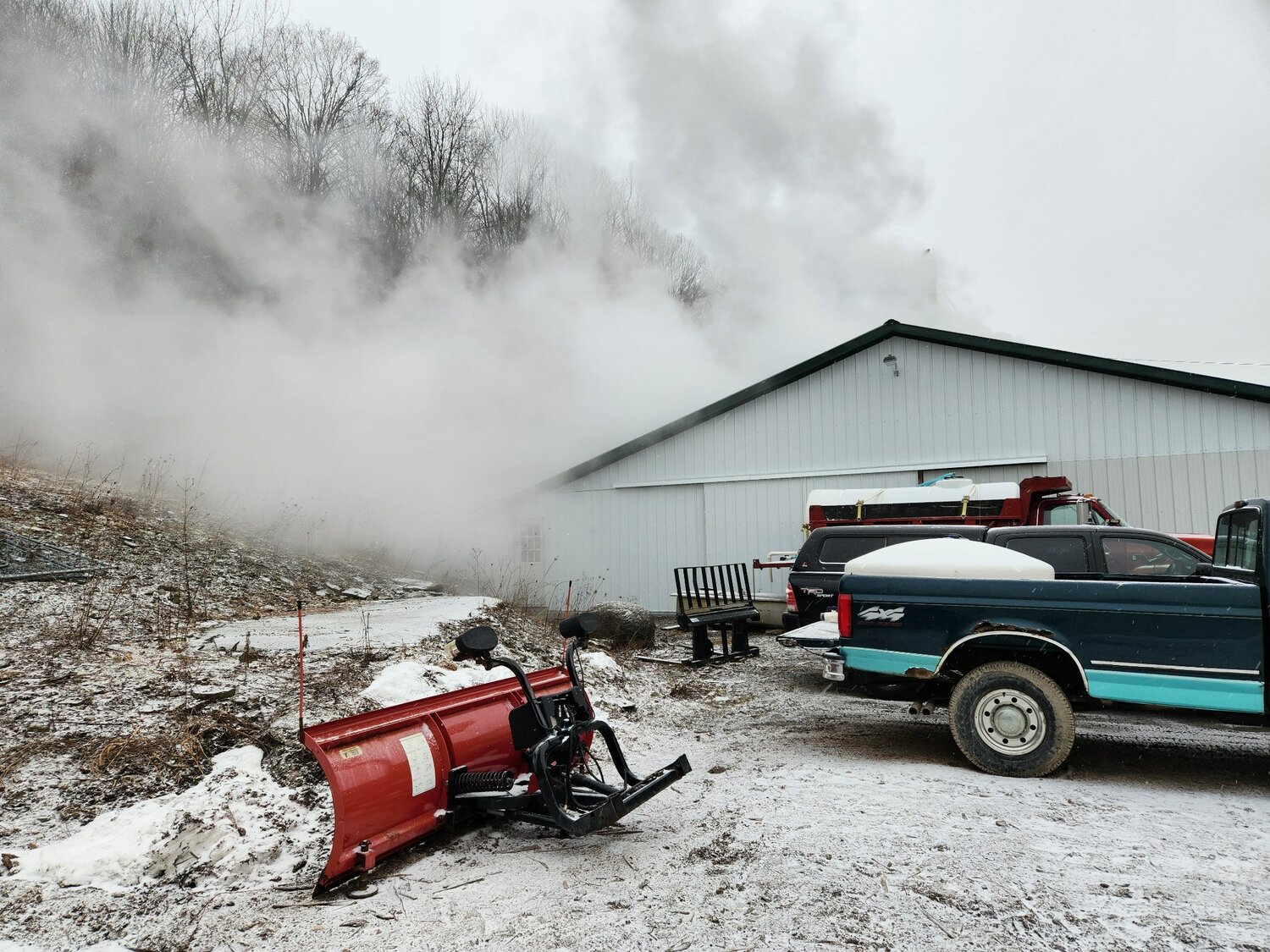 Many Maple Farms boils a large batch of sap in February, with the steam rising over the sugar house.