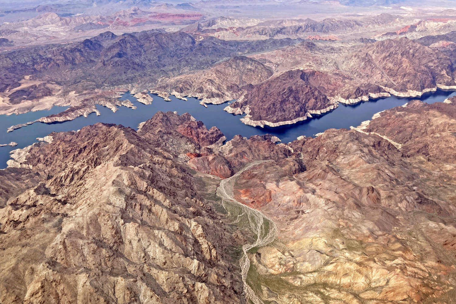 In this aerial photo, a bathtub ring of light minerals show the high water mark on the shore of Lake Mead along the border of Nevada and Arizona, Monday, March 6, near Boulder City, Nev. Record snowfall and rain have helped to loosen drought’s grip on parts of the western U.S. as national forecasters and climate experts warned Thursday, March 16, that some areas should expect more flooding as the snow begins to melt. Groundwater and reservoir storage levels — which take much longer to bounce back — remain at historic lows.