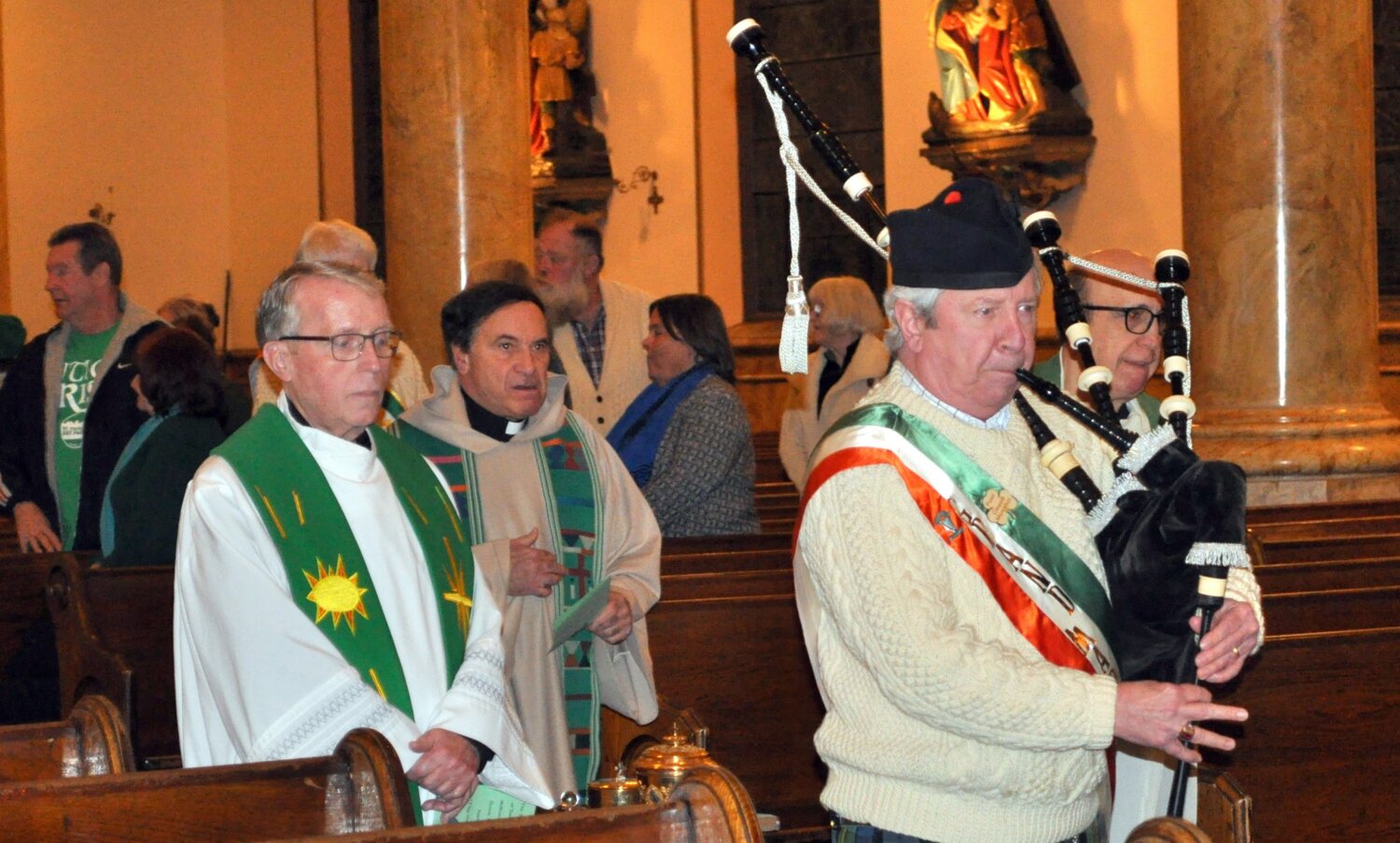 The honor of St. Patrick returned to its’ traditional home at St. Joseph and St. Patrick’s Church, the youth home parish of Saint Marianne Cope on Friday, March 17. For local Hibernians, the religious aspects of the celebration of the patron saint of Ireland is foremost in their observances and dozens of members of the Oneida County Ladies and Men’s Ancient Order of Hibernians were in attendance for the Mass. The principal celebrant was Rev.  Tom Servatius, who was joined by Deacon Tim Foley, Rev. Jim Cesta, Rev. Joe Salerno, and Peg O’Toole, of the LAOH.