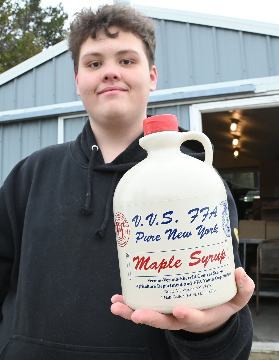 Ethan Vierow, a VVS sophomore, holds up a just-filled half gallon of maple syrup Friday, March 10 outside of the VVS FFA's sap house in Verona.