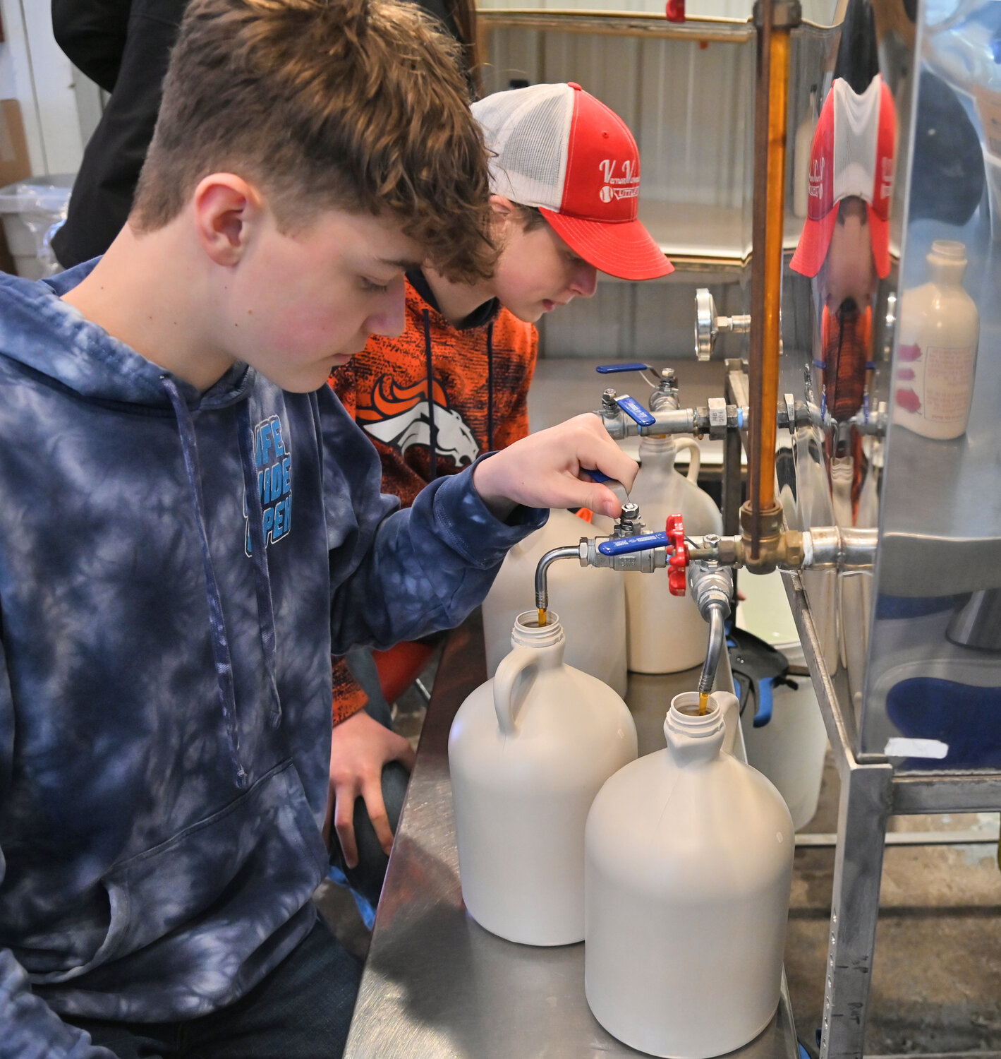 VVS junior and FFA president Devon Conley fills a gallon jug with maple syrup Friday, March 10 in their sap house in Verona. Next to him is junior Mark Hoffman.